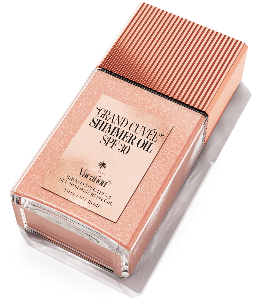 A rectangular bottle of shimmery rose gold "Vacation Grand Cuvée Shimmer Oil SPF 30" with a ridged cap.