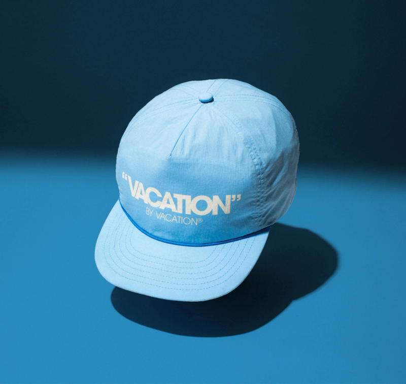 a light blue hat that says " vacation " on it