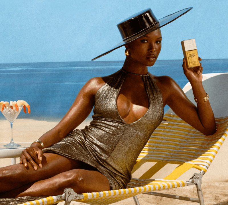 a woman in a gold dress is laying on a beach chair