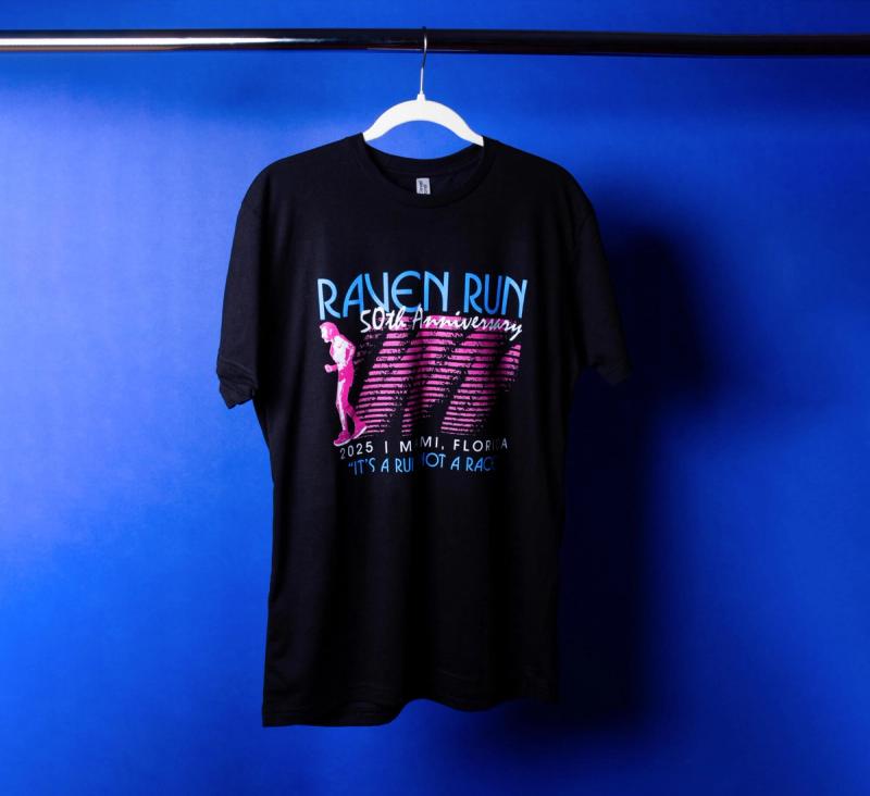 a black Raven Run t-shirt is hanging on a hanger on a blue background