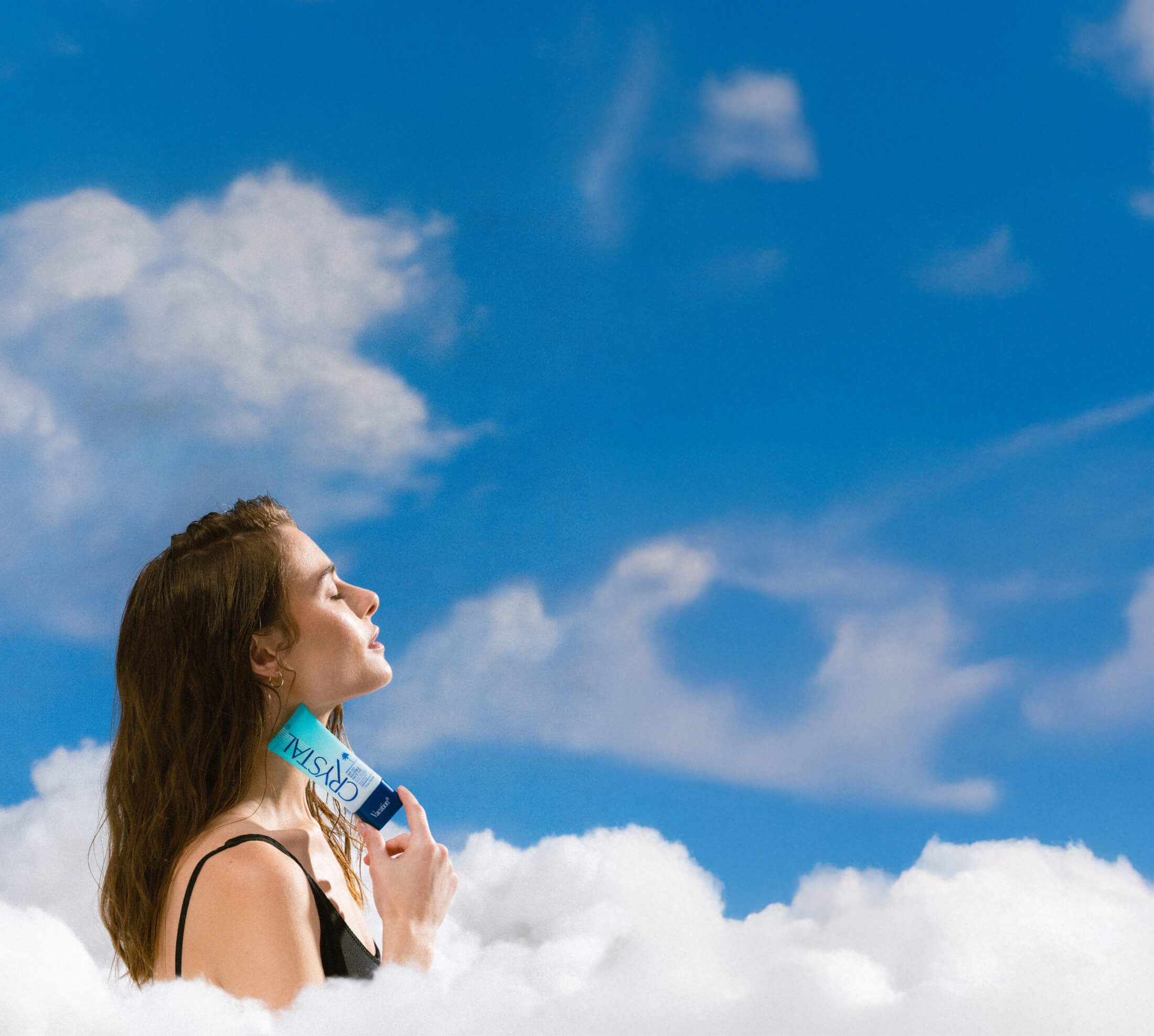 a woman is standing in the clouds holding a bottle of crystal gel