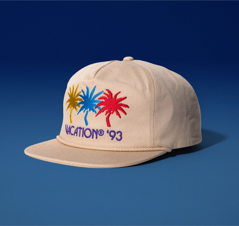 A Vacation® Jazz Palms Rope Hat, with a yellow, blue, and pink palm tree reading "Vacation® '93"