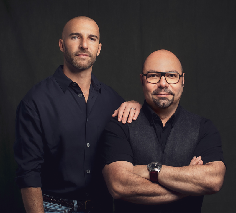 Carlos and Rodrigo standing next to each other with their arms crossed