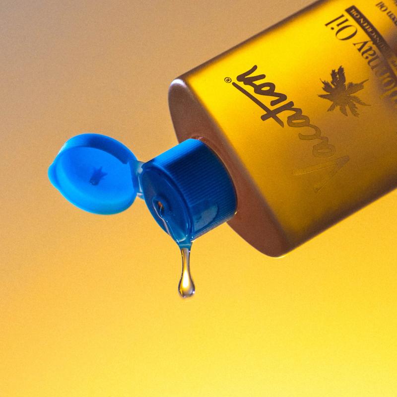 a bottle of lotion with a drop of liquid coming out of it