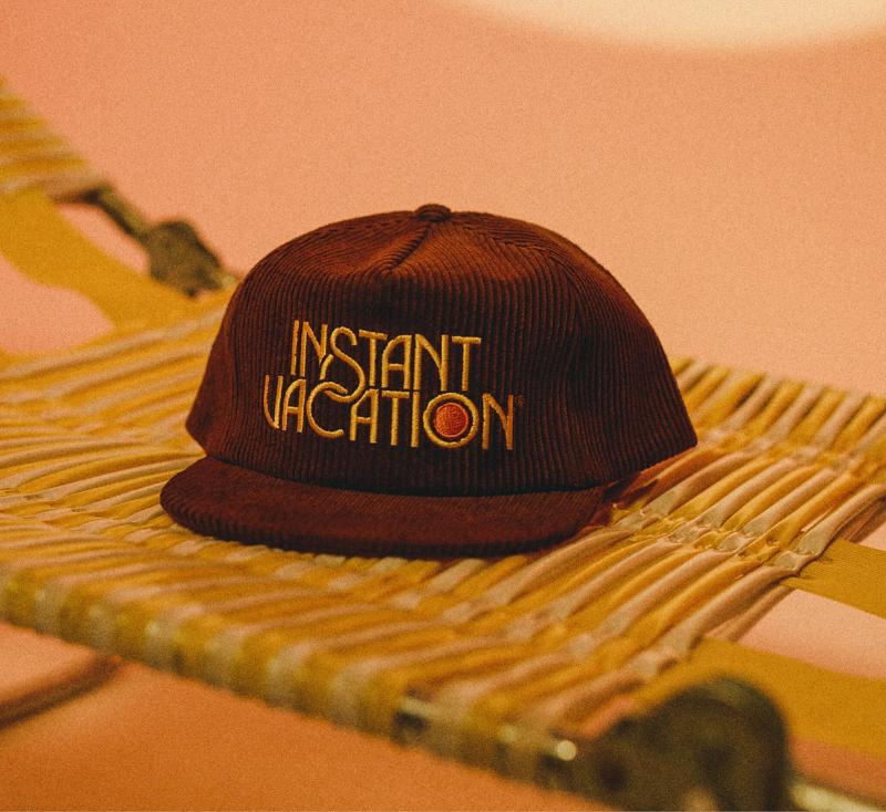 An Instant Vacation® Corduroy Hat atop a beach lounger