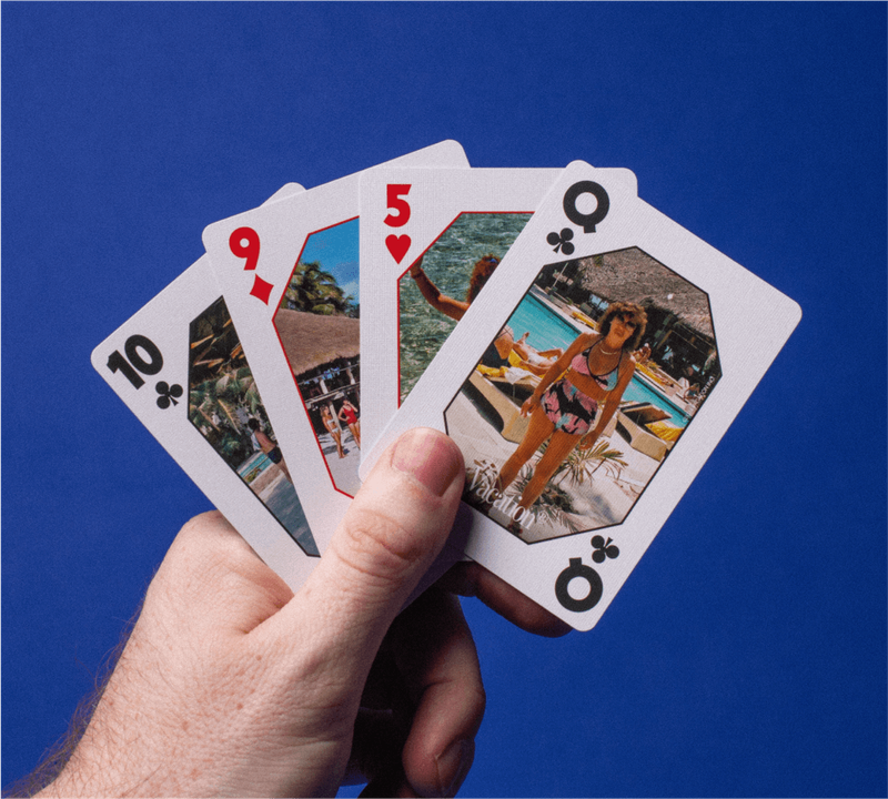 a hand is holding four playing cards with pictures on them