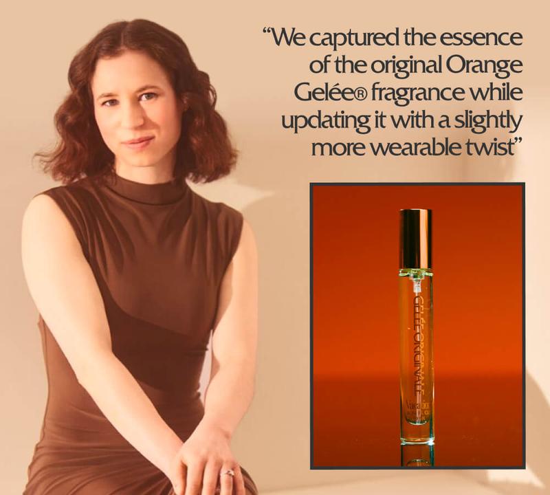 A woman in a brown dress sits next to a perfume bottle filled with orange liquid. Accompanying text describes updating the original Orange Gelée® fragrance.