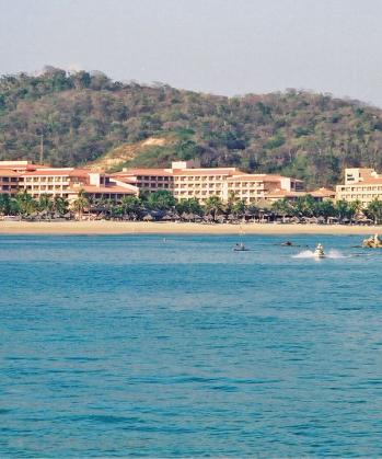 Large resort complex on a sandy beach with palm trees