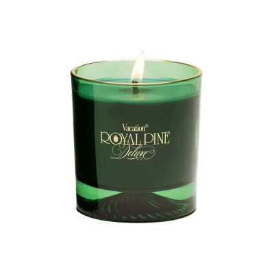 a green candle that says vacation royal pine deluxe in gold