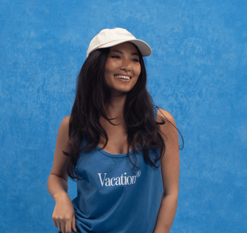 a woman wearing a blue tank top and a Vacation® tone-on-tone hat