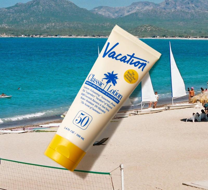 A tube of Vacation Classic Lotion Broad Spectrum SPF 50 Sunscreen is shown over a sunny beach scene with turquoise water, sailboats, and a volleyball net.