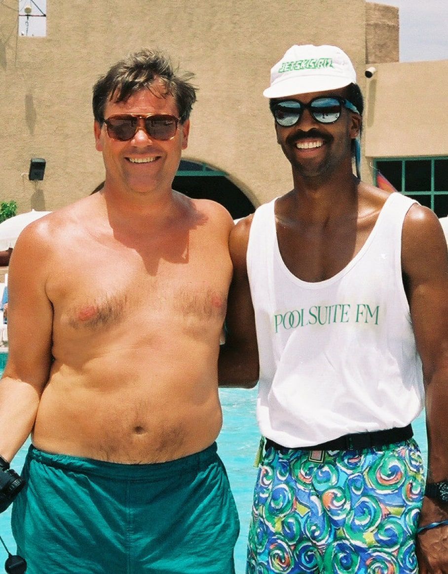a man wearing a tank top that says pool suite fm
