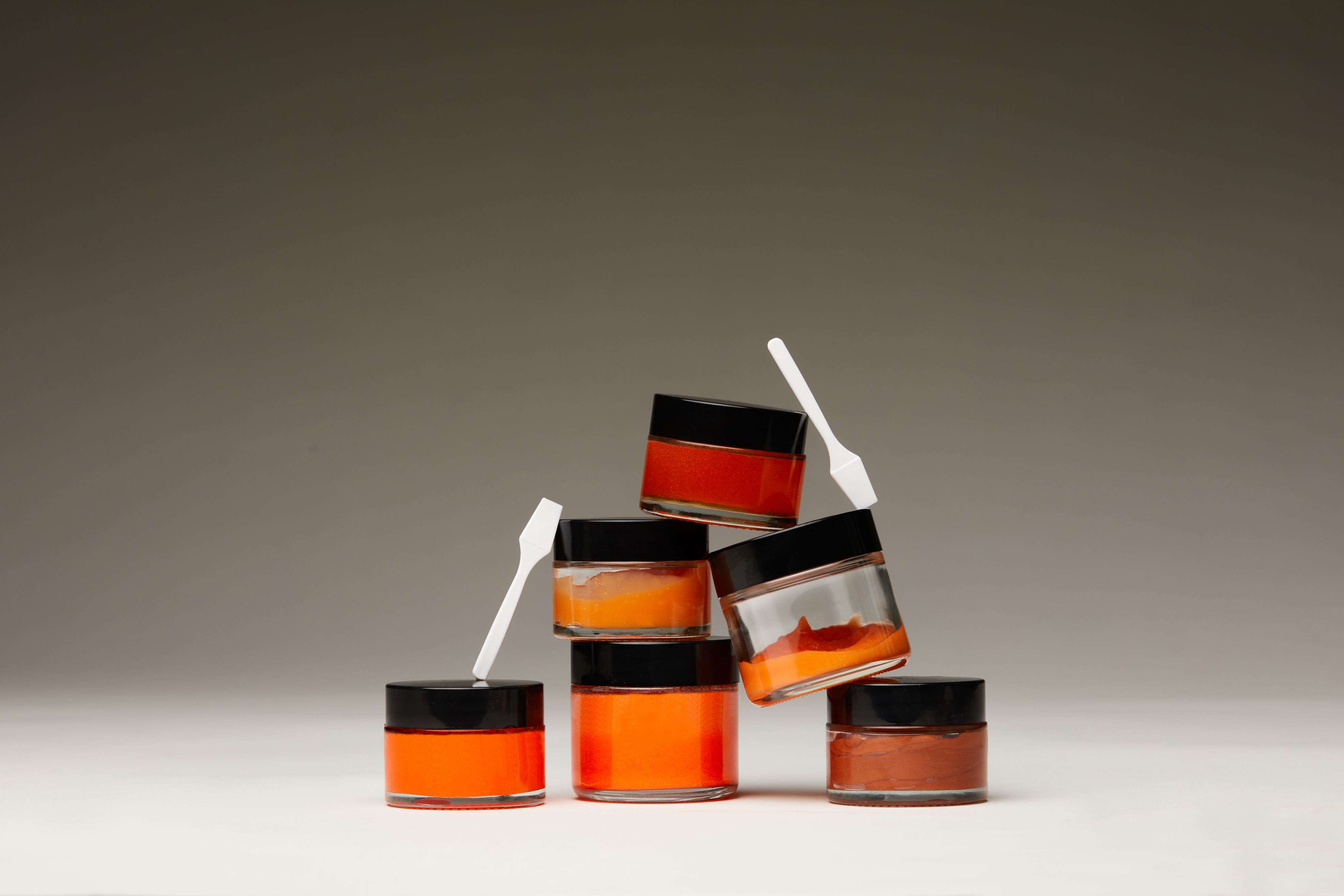 a group of jars stacked on top of each other with spoons in them .