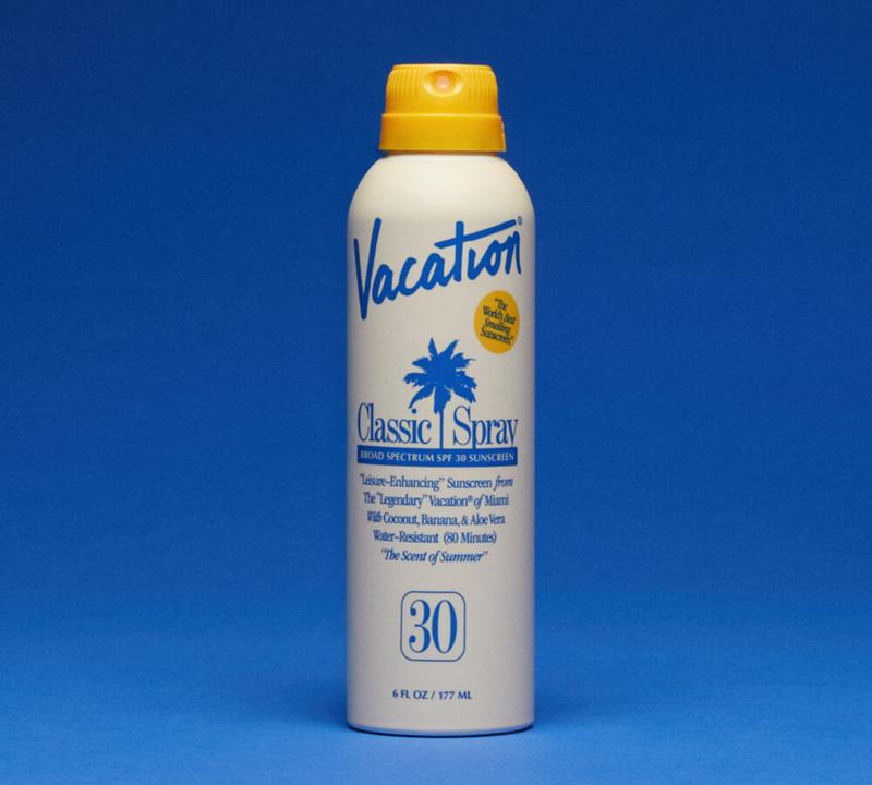 A white spray can of Vacation Classic Spray SPF 30 sunscreen with a yellow cap.