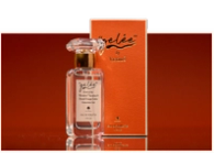 A clear glass perfume bottle with a decorative stopper stands next to an orange box.