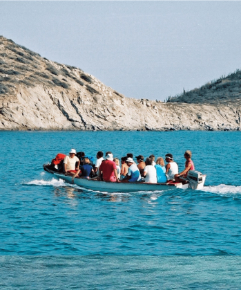 a group of people are in a small boat in the ocean