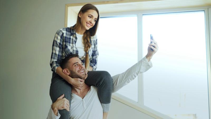 Couple taking a selfie by the window