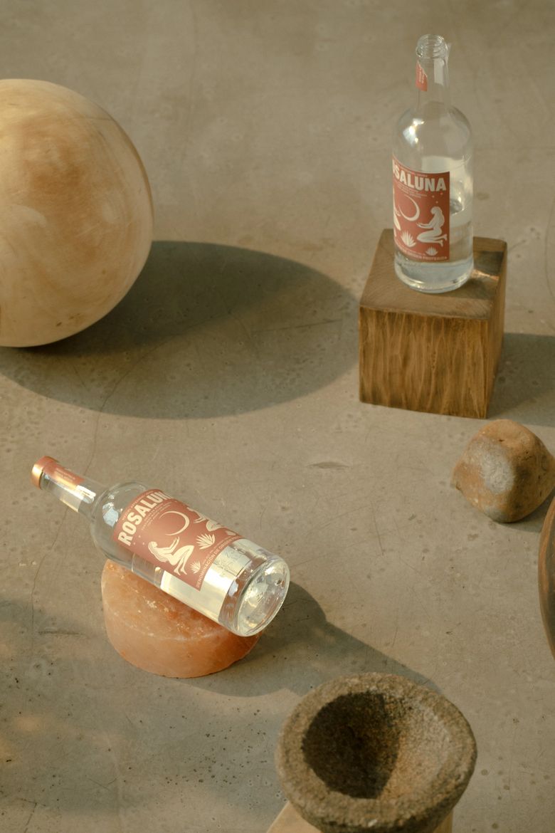 Still life of Rosaluna Mezcal bottles, wood, stones, and various objects