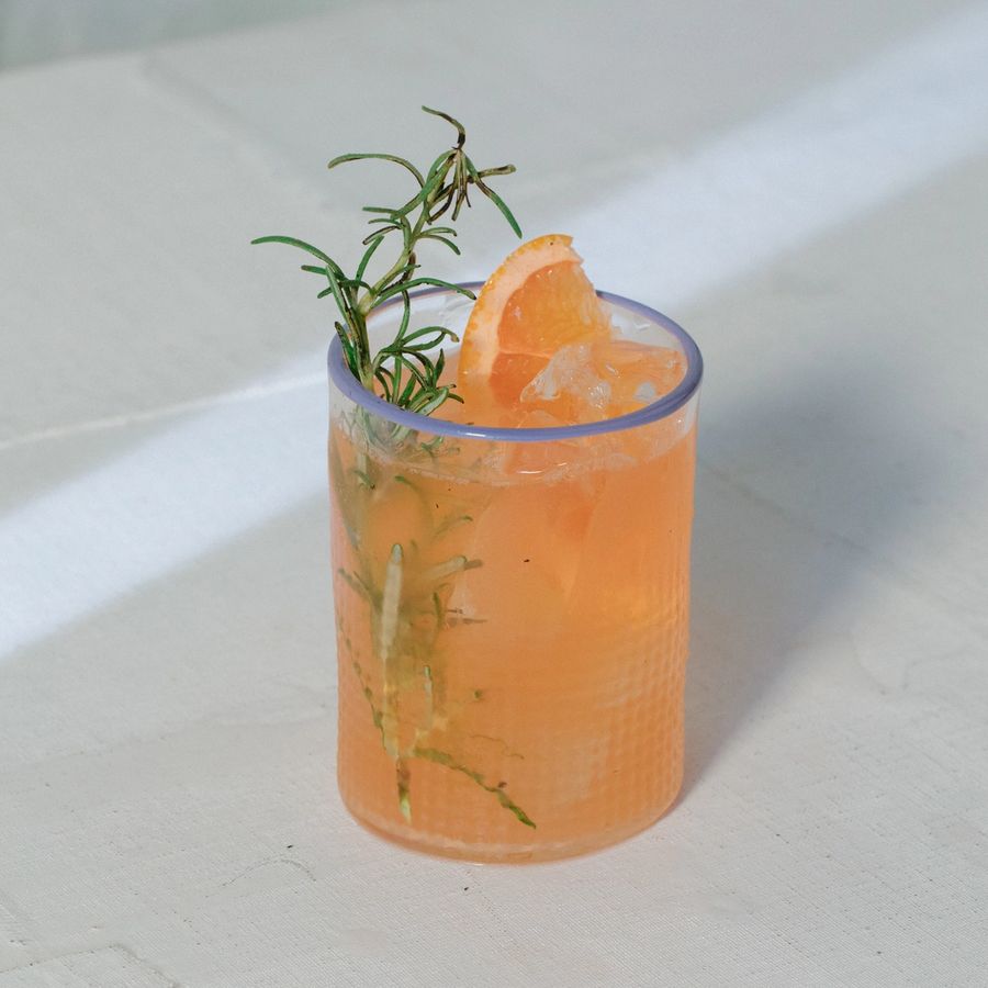Rosaluna Smoky Paloma drink with torched rosemary sprig garnish