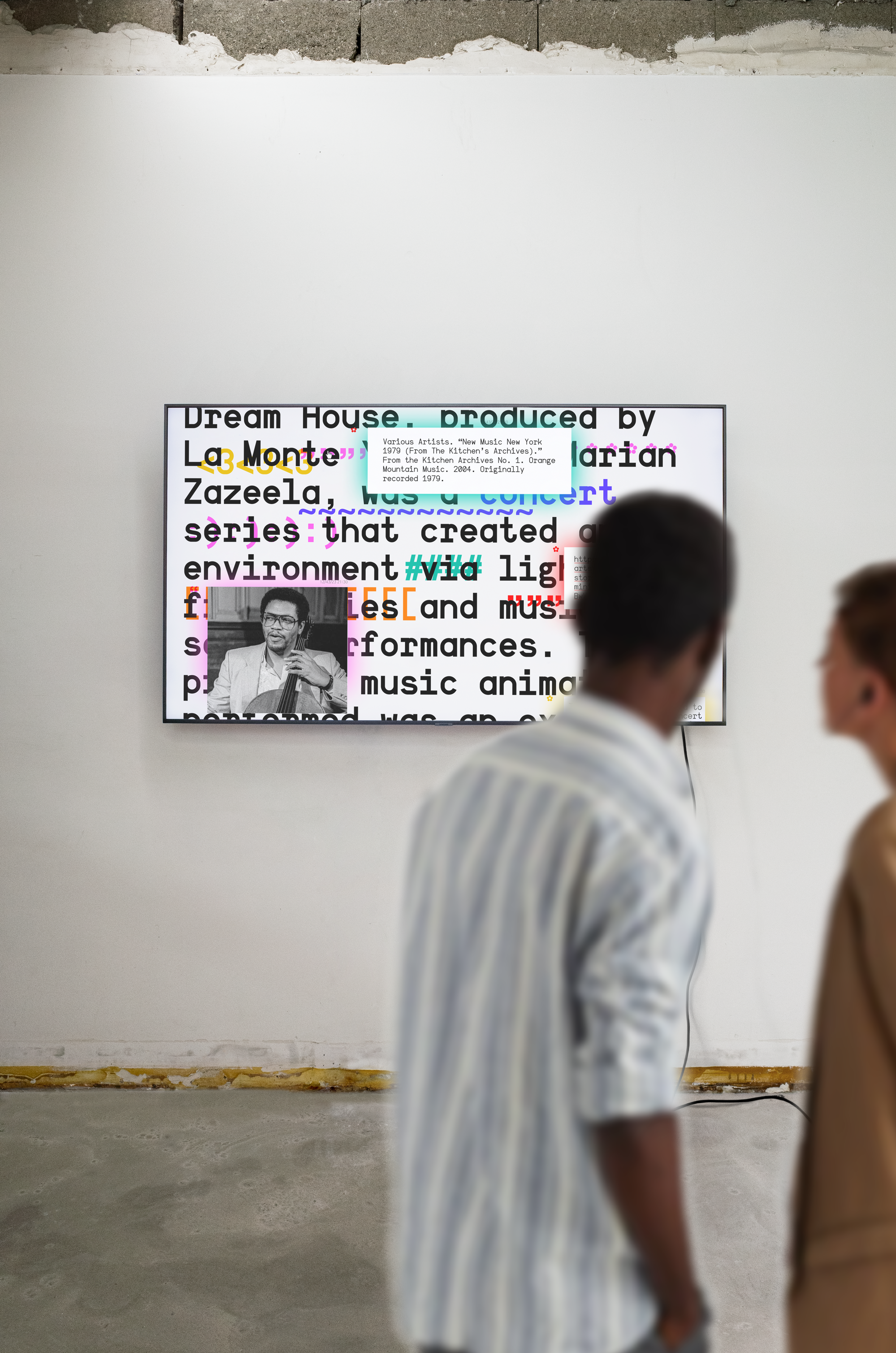Photo view of words changing into different colors on a monitor with people looking. Copyright Cotton Design, Talia Cotton