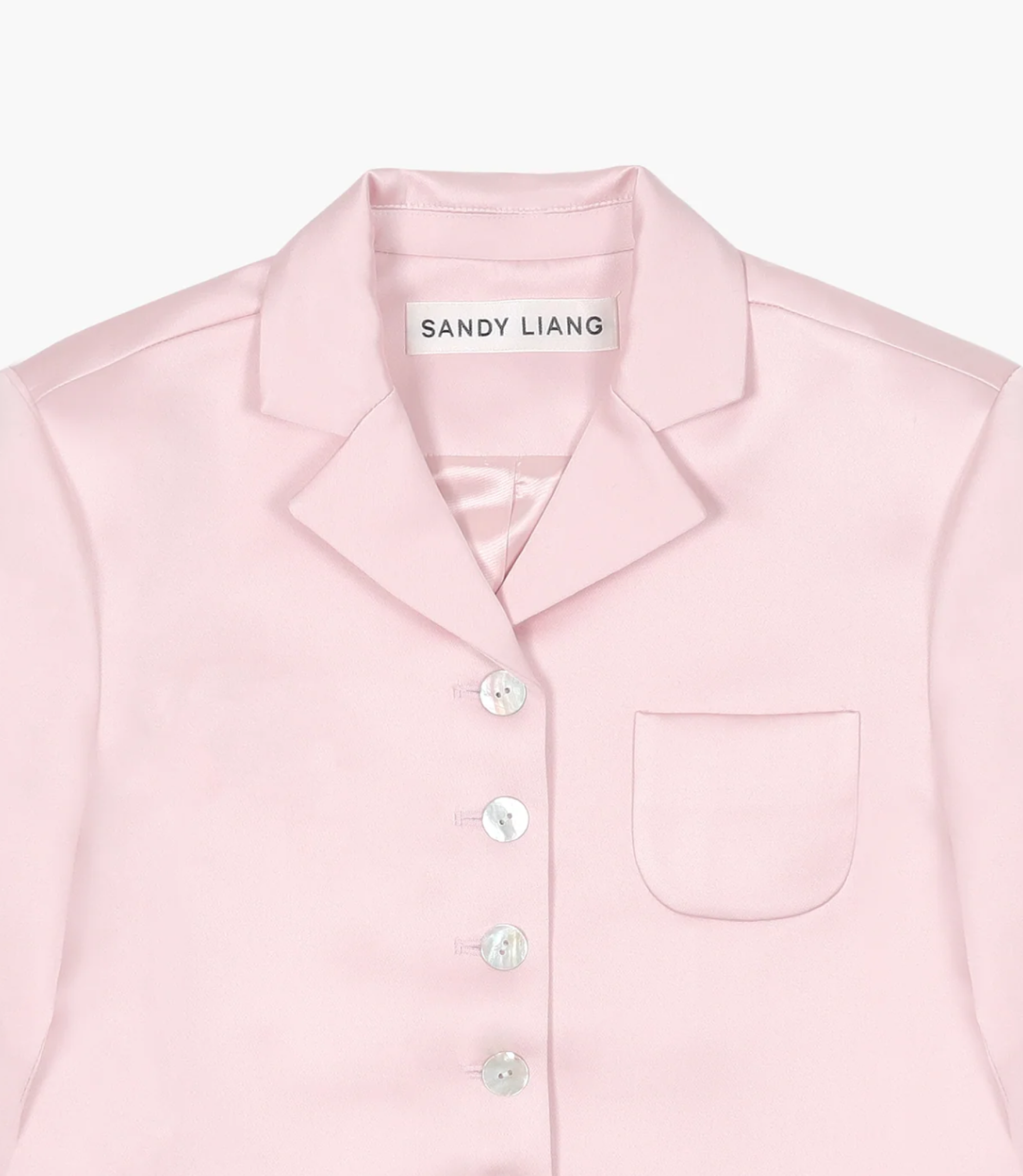 Sandy Liang pink button down shirt with logo on label. Copyright Cotton Design, Talia Cotton