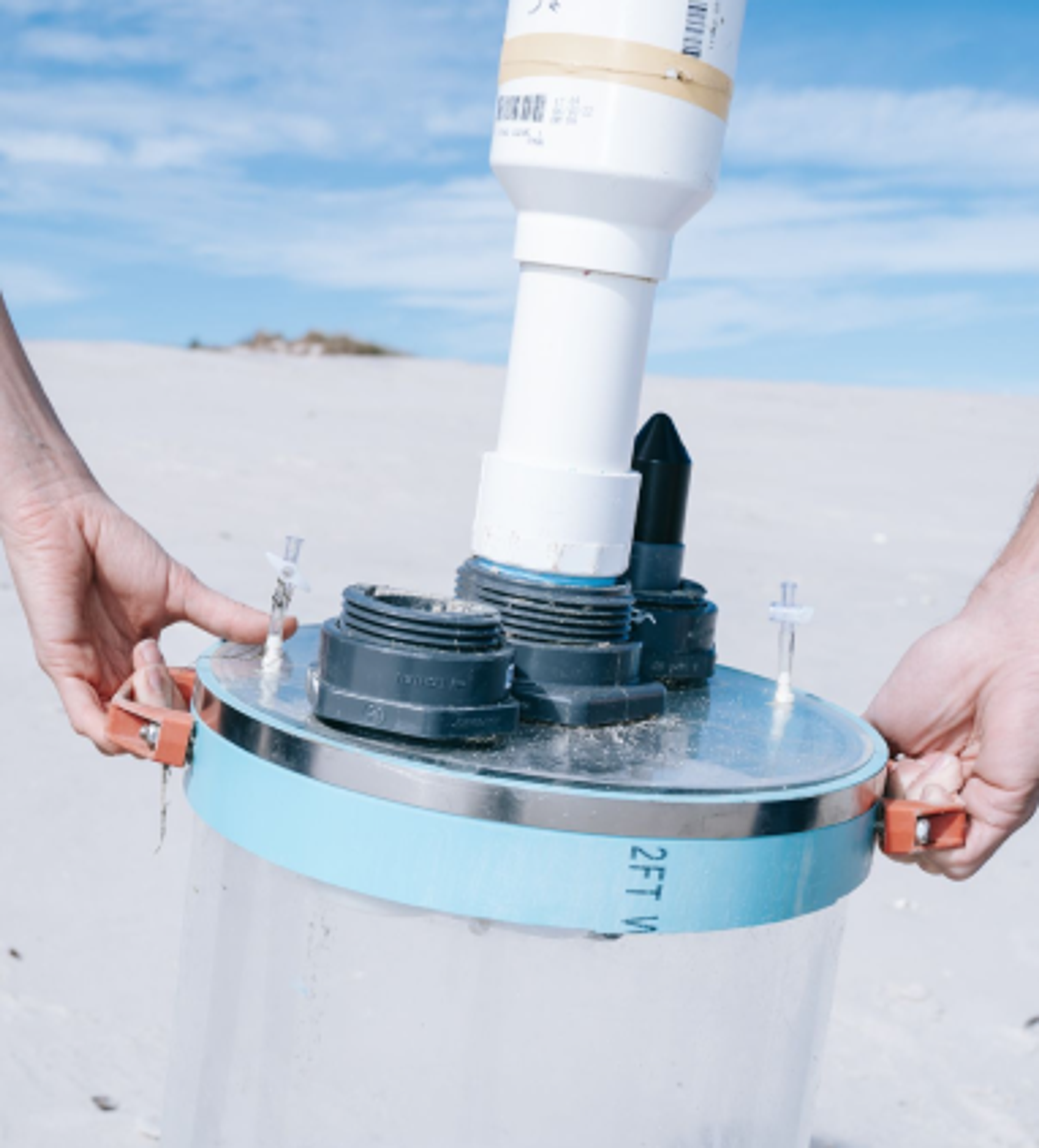 Holding a water filtration jug in a sandy environment. Copyright Cotton Design, Talia Cotton