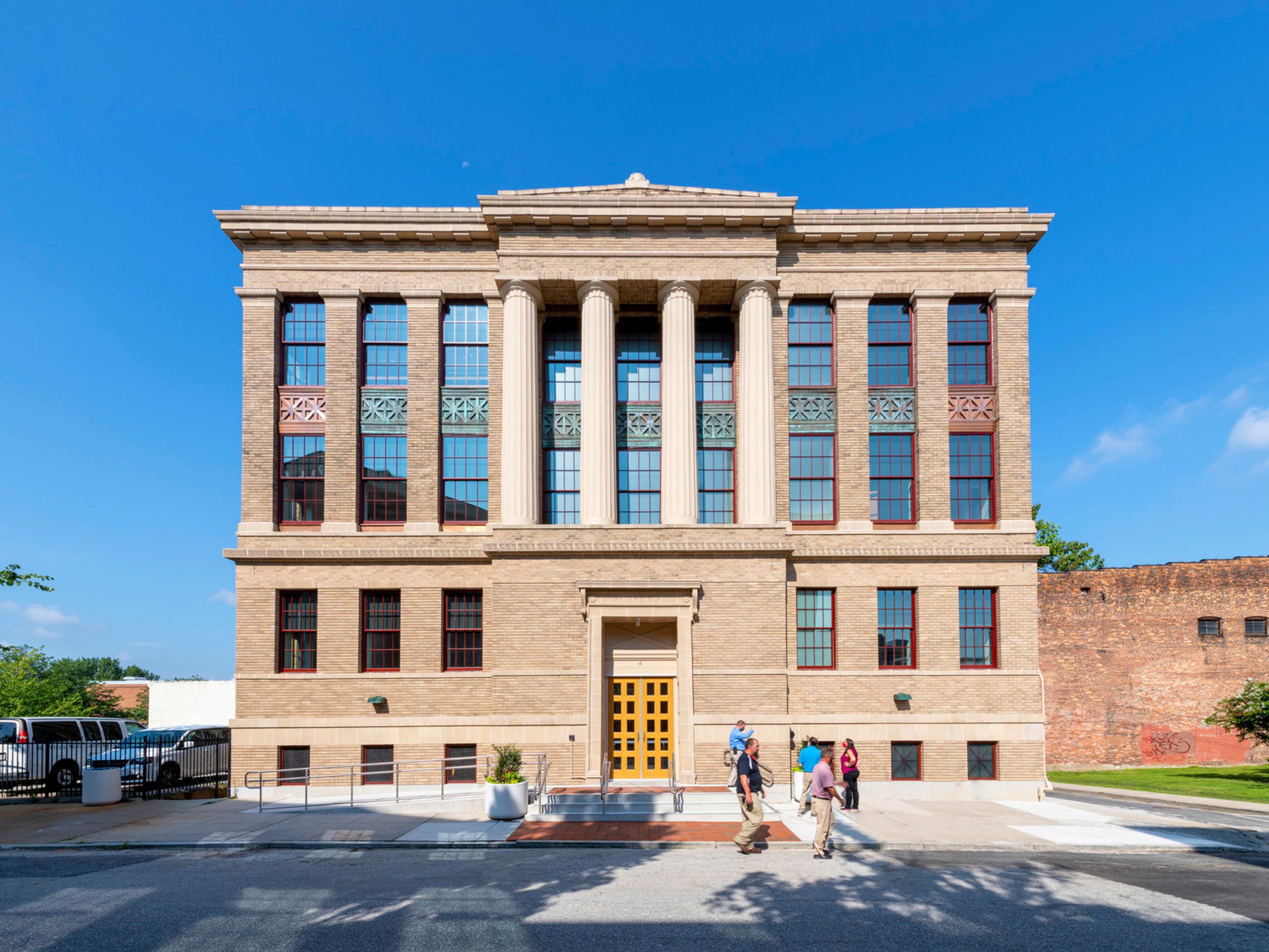 Pedestrians Walking in Front of Multi-Story Building