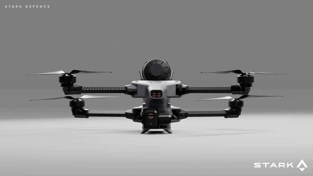 A dark gray drone with four propellers and multiple sensors on a plain gray background.