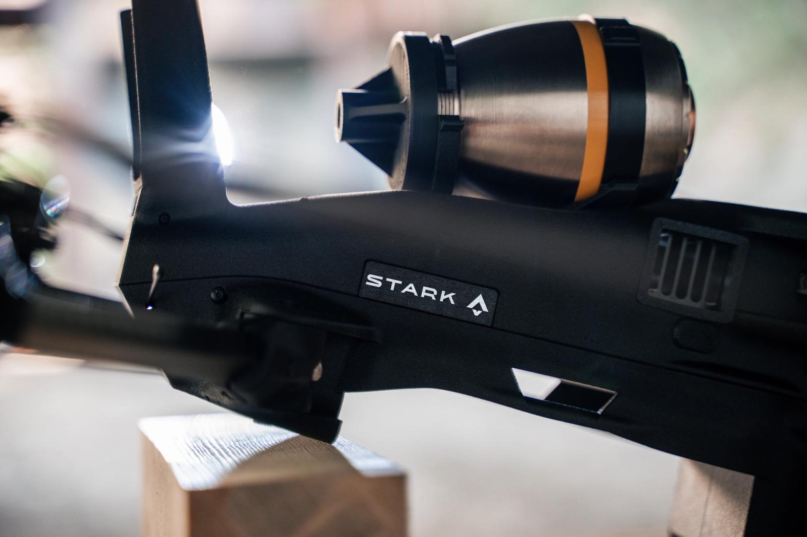 Black Stark-branded drone with a mounted cylindrical sensor, brightly illuminated.