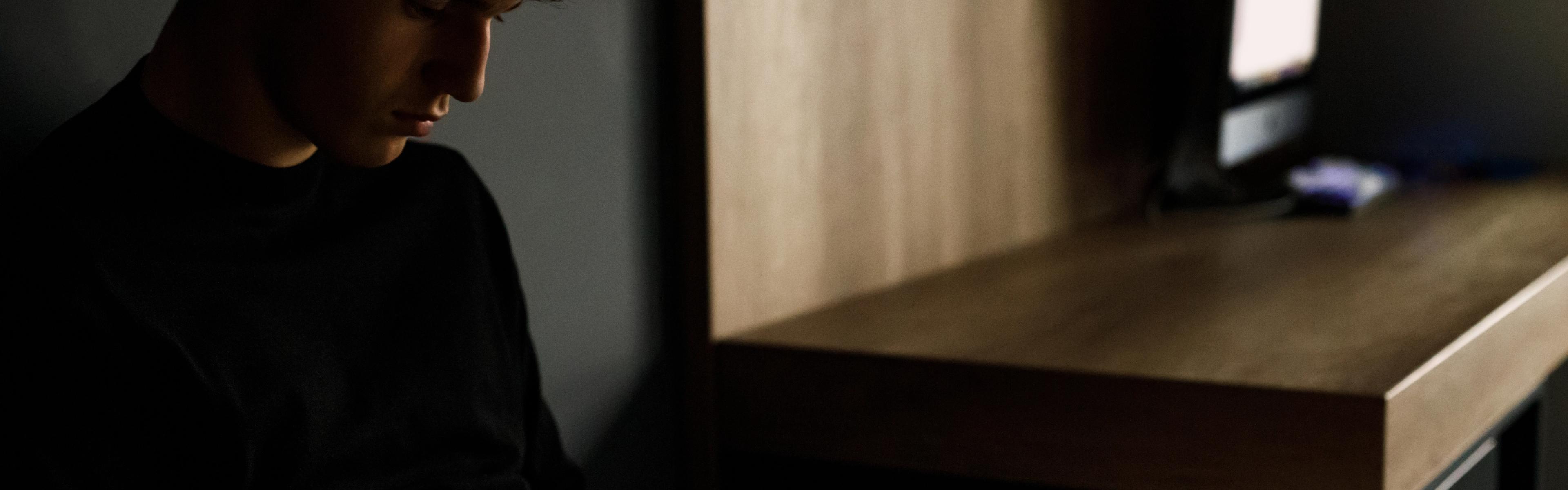 En dreng sidder med sin mobiltelefon.