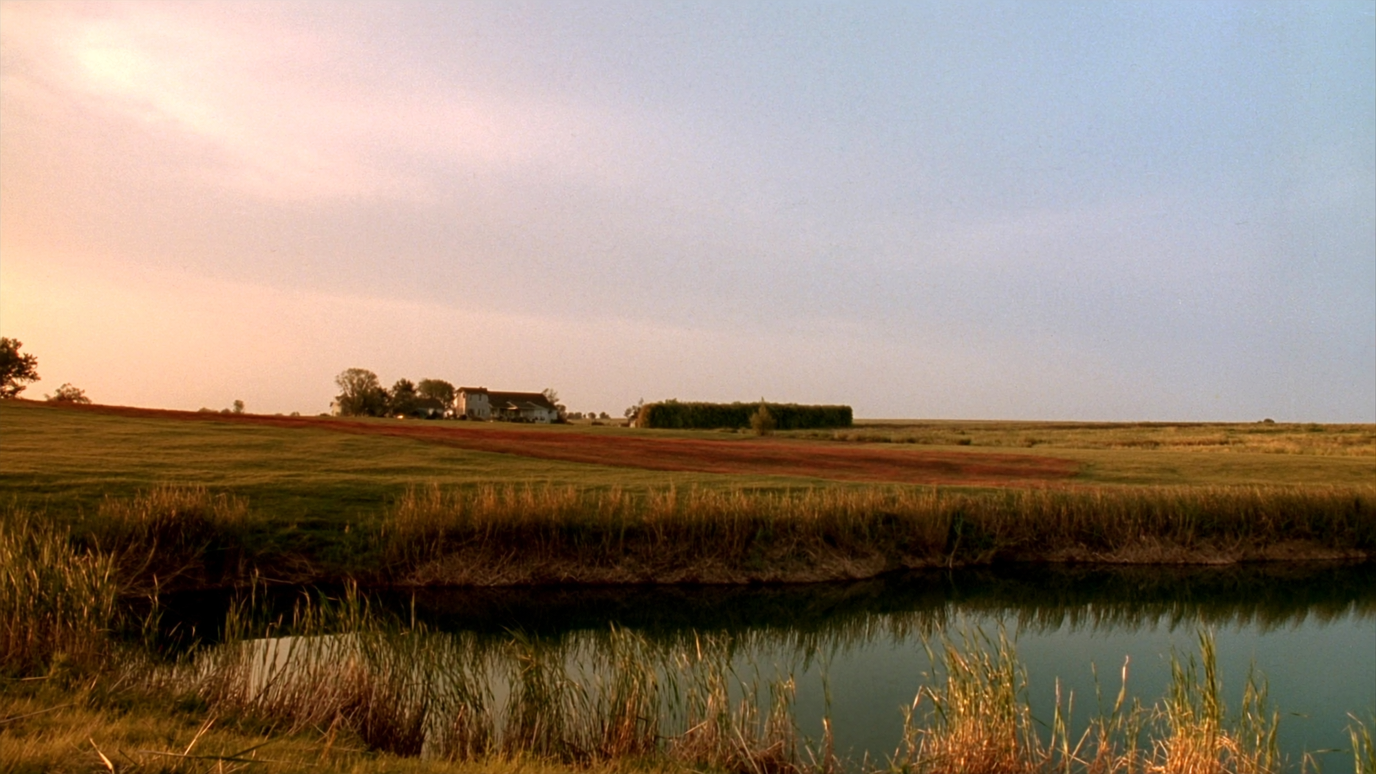 A clean acreage pond on a prairie property at golden hour