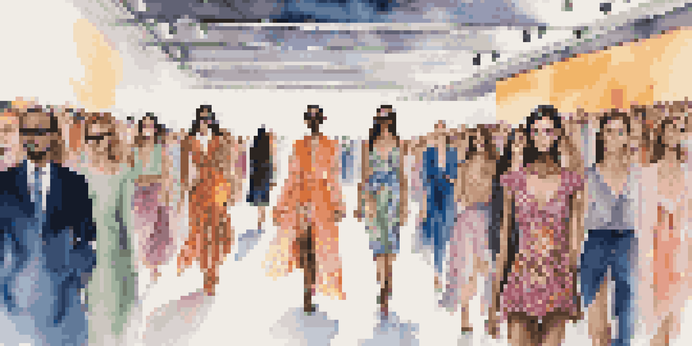A lively fashion runway with diverse models displaying colorful clothes, surrounded by an engaged audience and dramatic lighting.