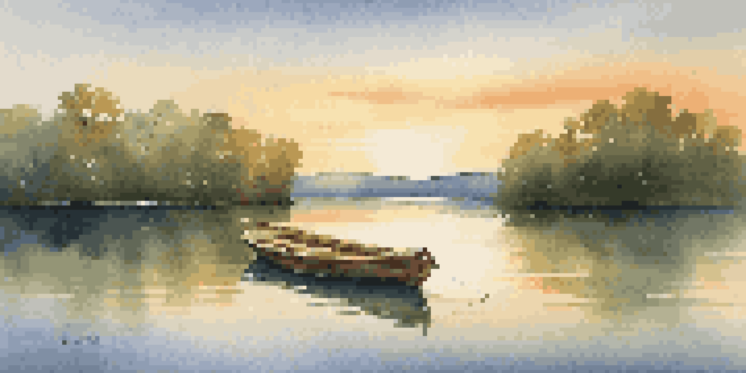 A peaceful lake at sunset with lush trees and a small wooden boat floating on the water.