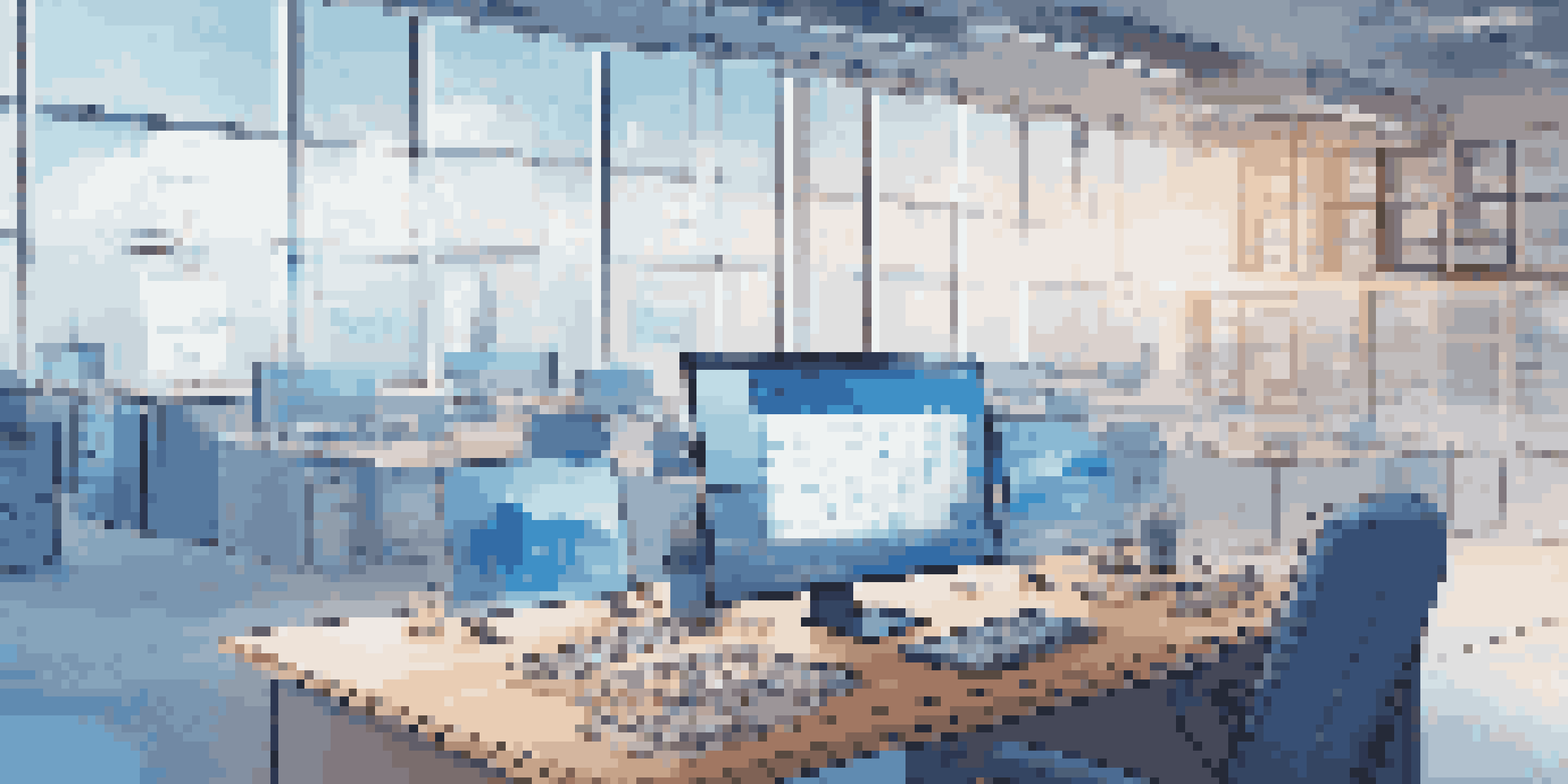 A modern office workspace with a laptop displaying code, surrounded by cloud icons and digital network visuals, illuminated by soft natural light.