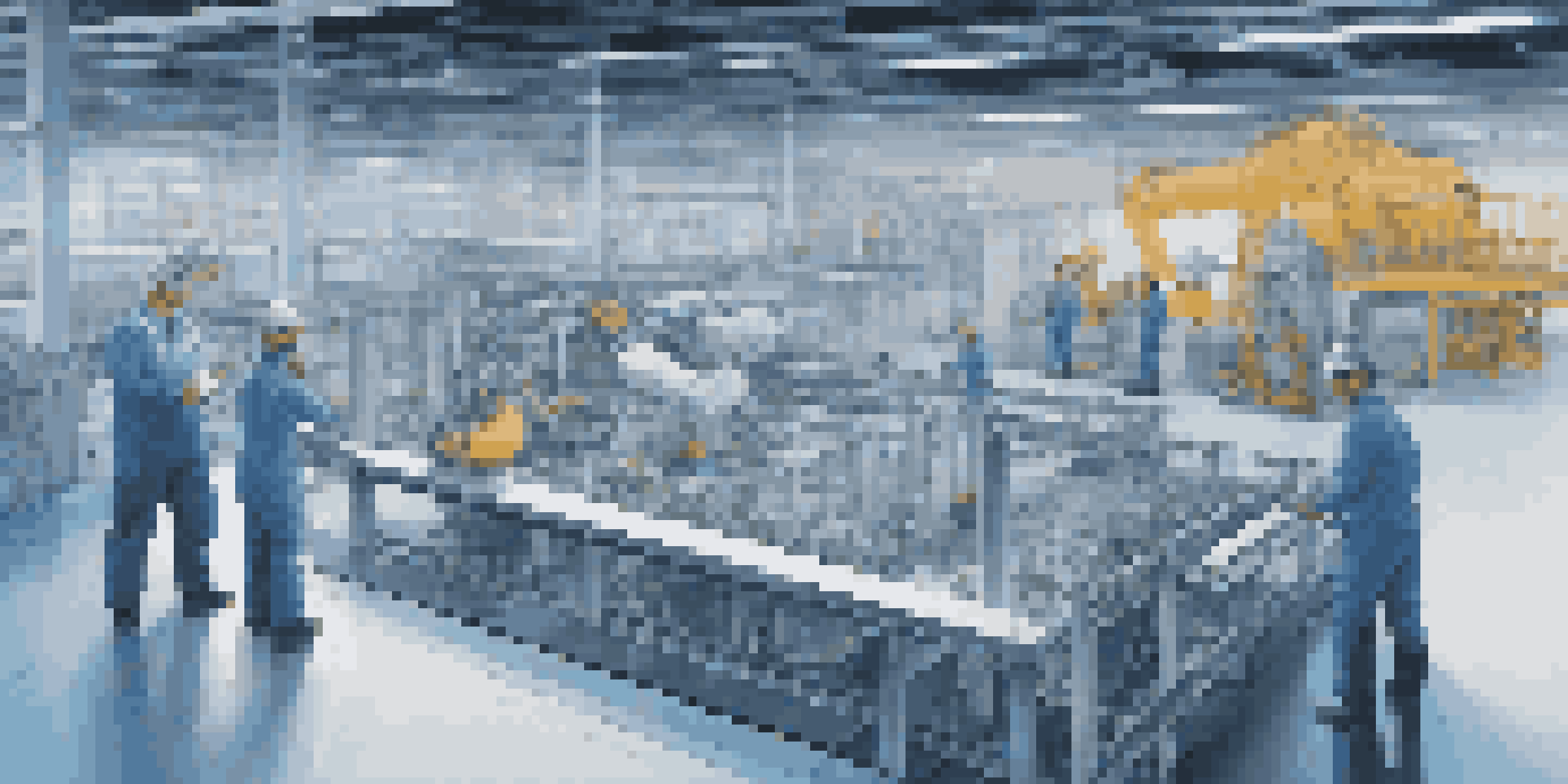 A modern manufacturing facility with engineers looking at a large screen displaying a digital twin model of machinery.