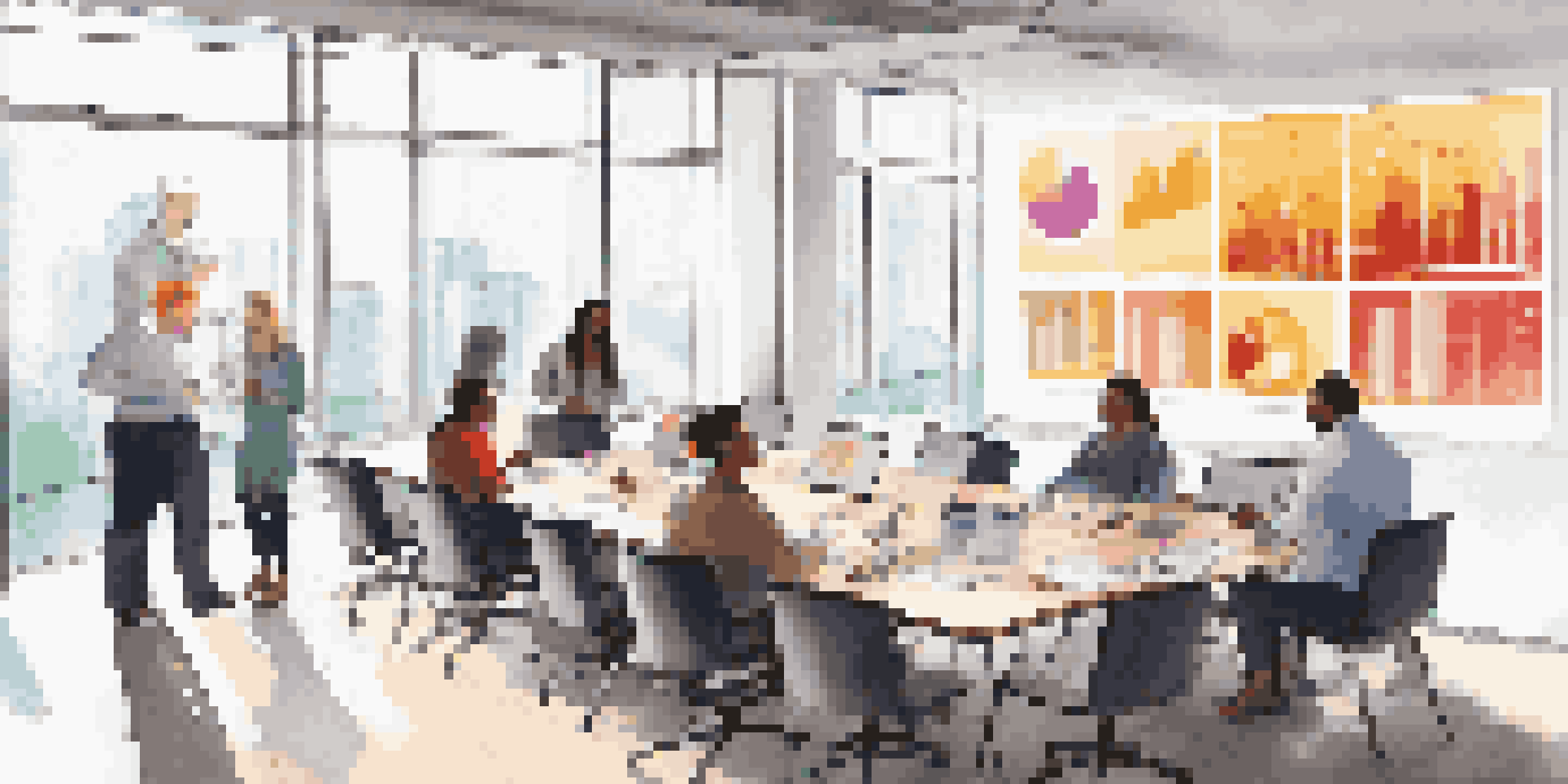 A diverse group of team members in a bright meeting room discussing colorful data visualizations displayed on a large screen.