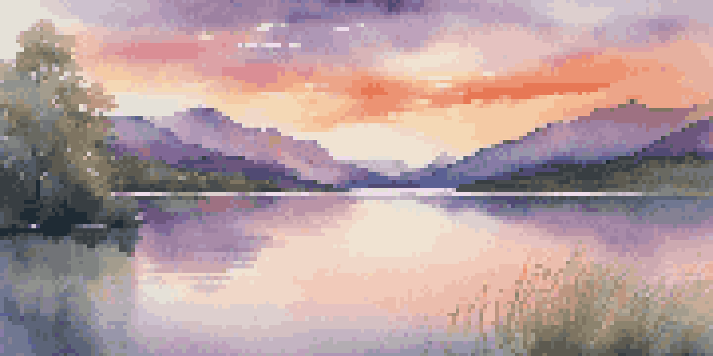 A peaceful sunset over a lake with mountains and colorful sky, surrounded by green trees.