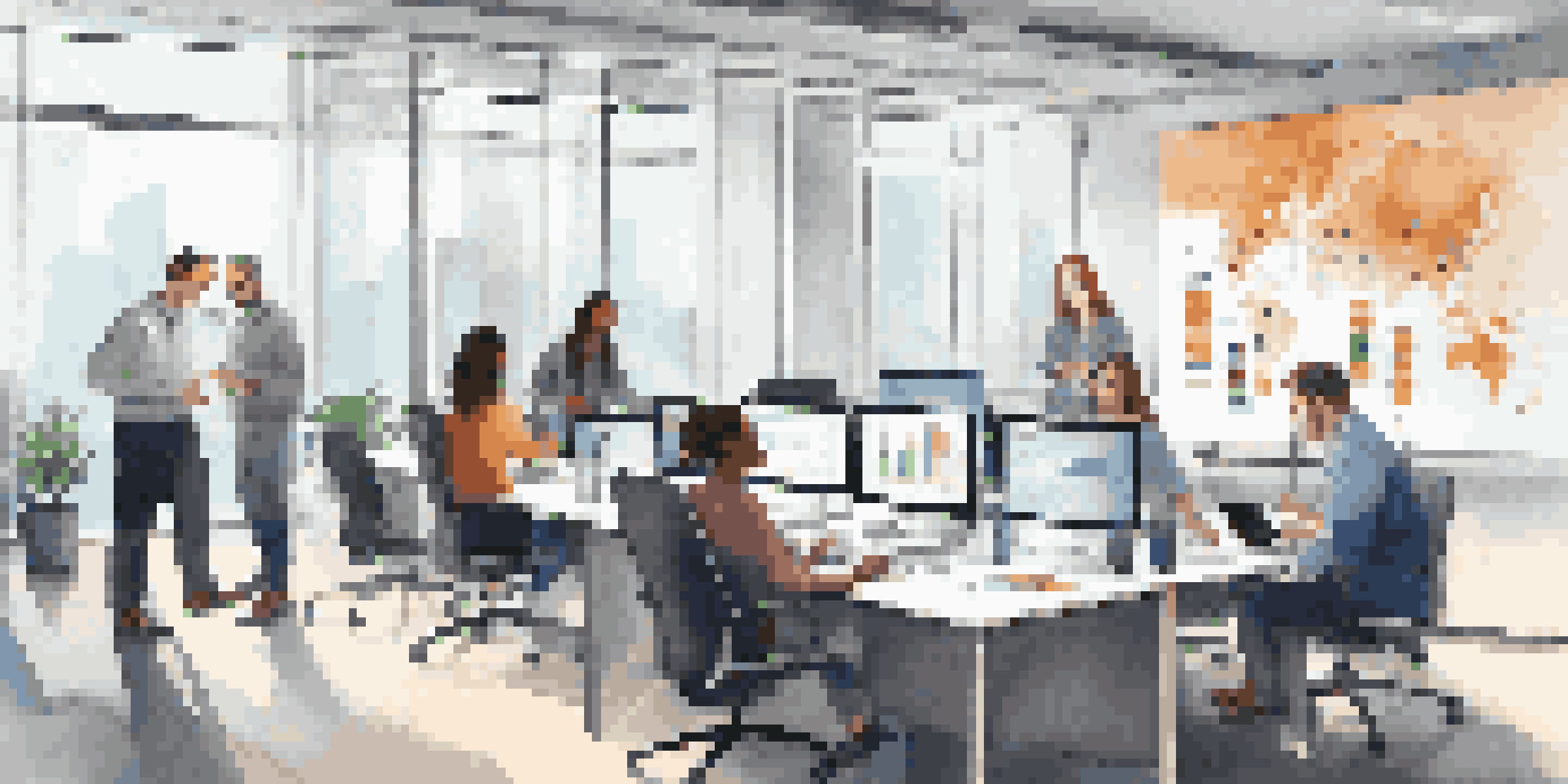 A diverse team collaborating in an office, discussing data governance strategies with laptops and charts.