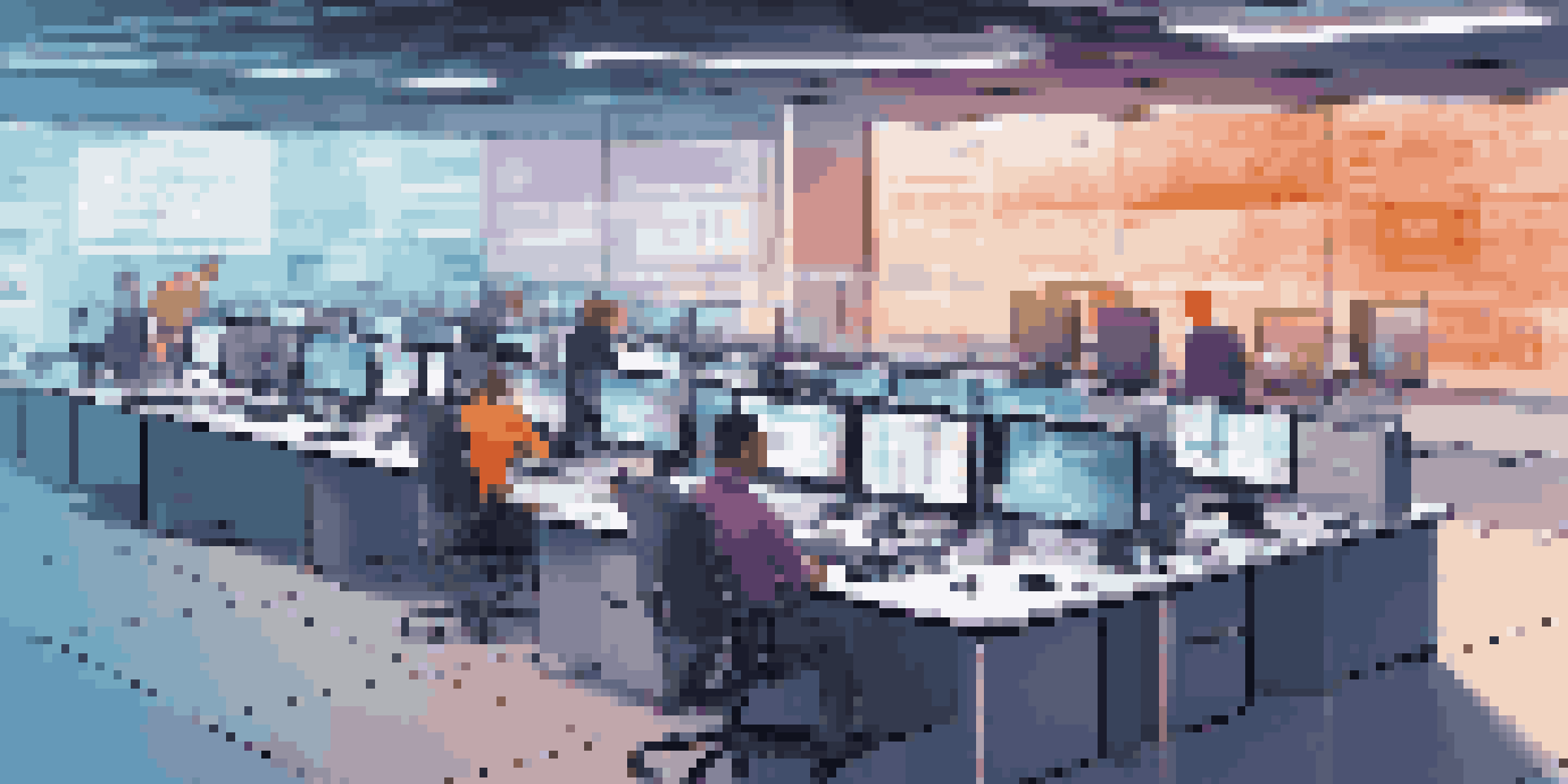 A modern IT service desk featuring monitors with real-time data and an IT team member communicating with a user.