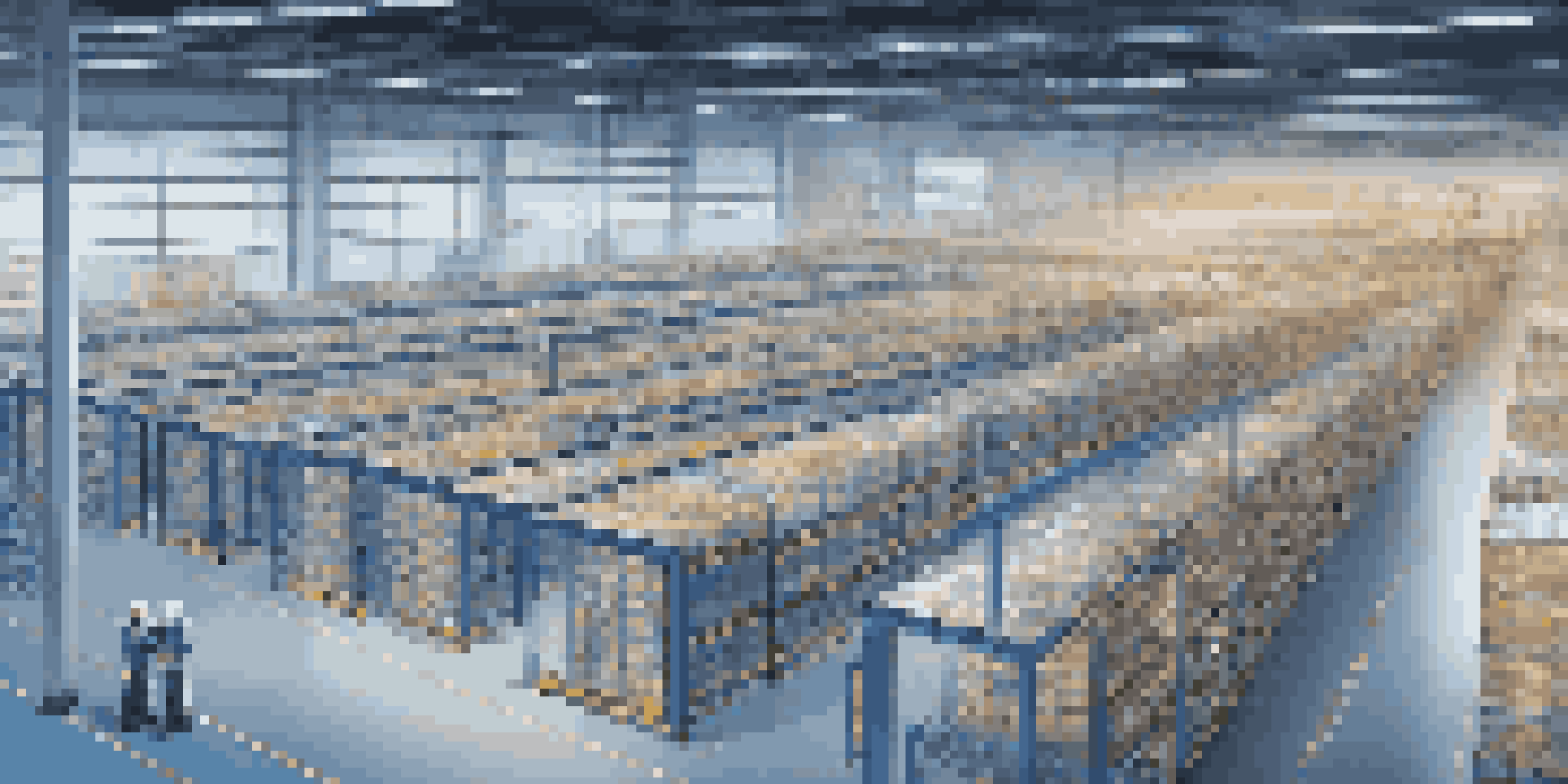 A modern warehouse with digital twin screens showing real-time supply chain data, illuminated by soft blue and white lights, with workers engaging with the technology.