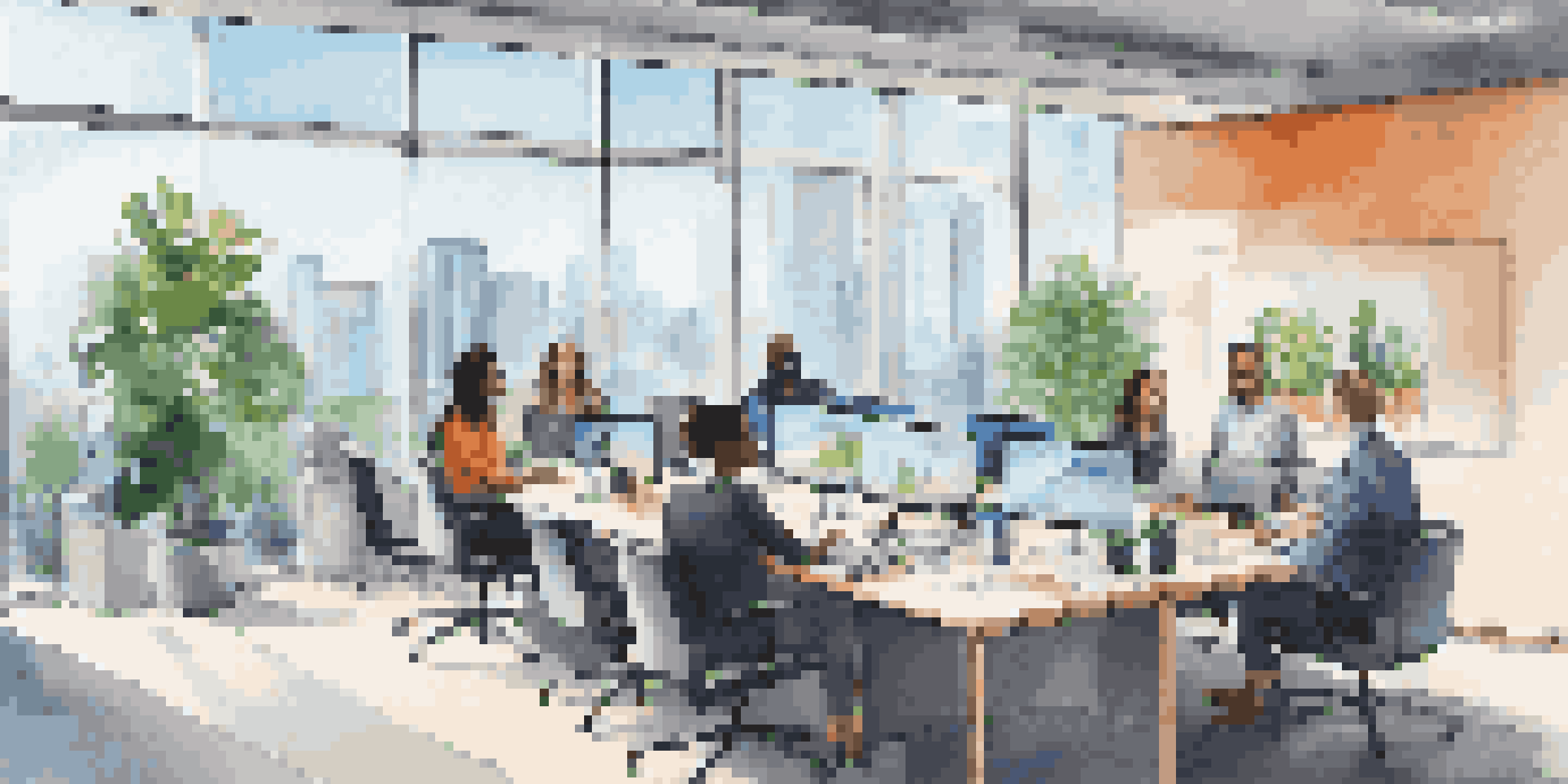 A modern office where diverse employees are participating in a virtual meeting, with a city view outside the windows.