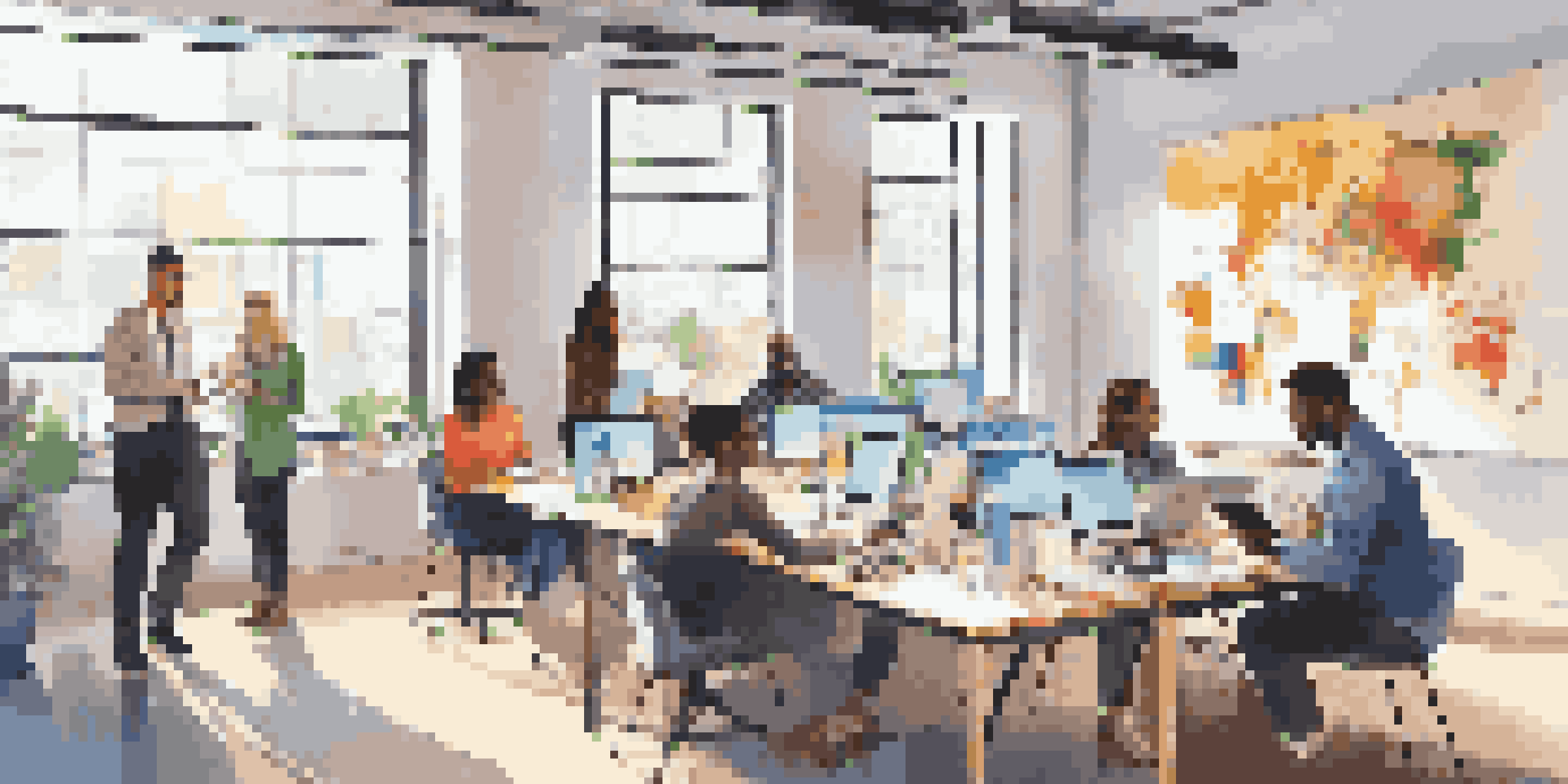 A diverse group of nonprofit staff members collaborating in a bright office, using digital tools.