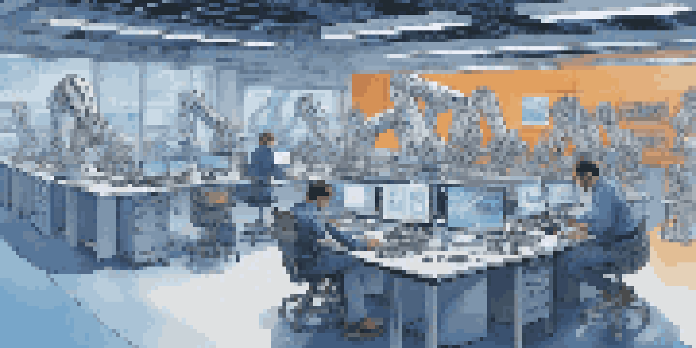 A robotics lab featuring engineers and digital twin models on screens, with a robotic arm in the foreground and bright LED lighting.