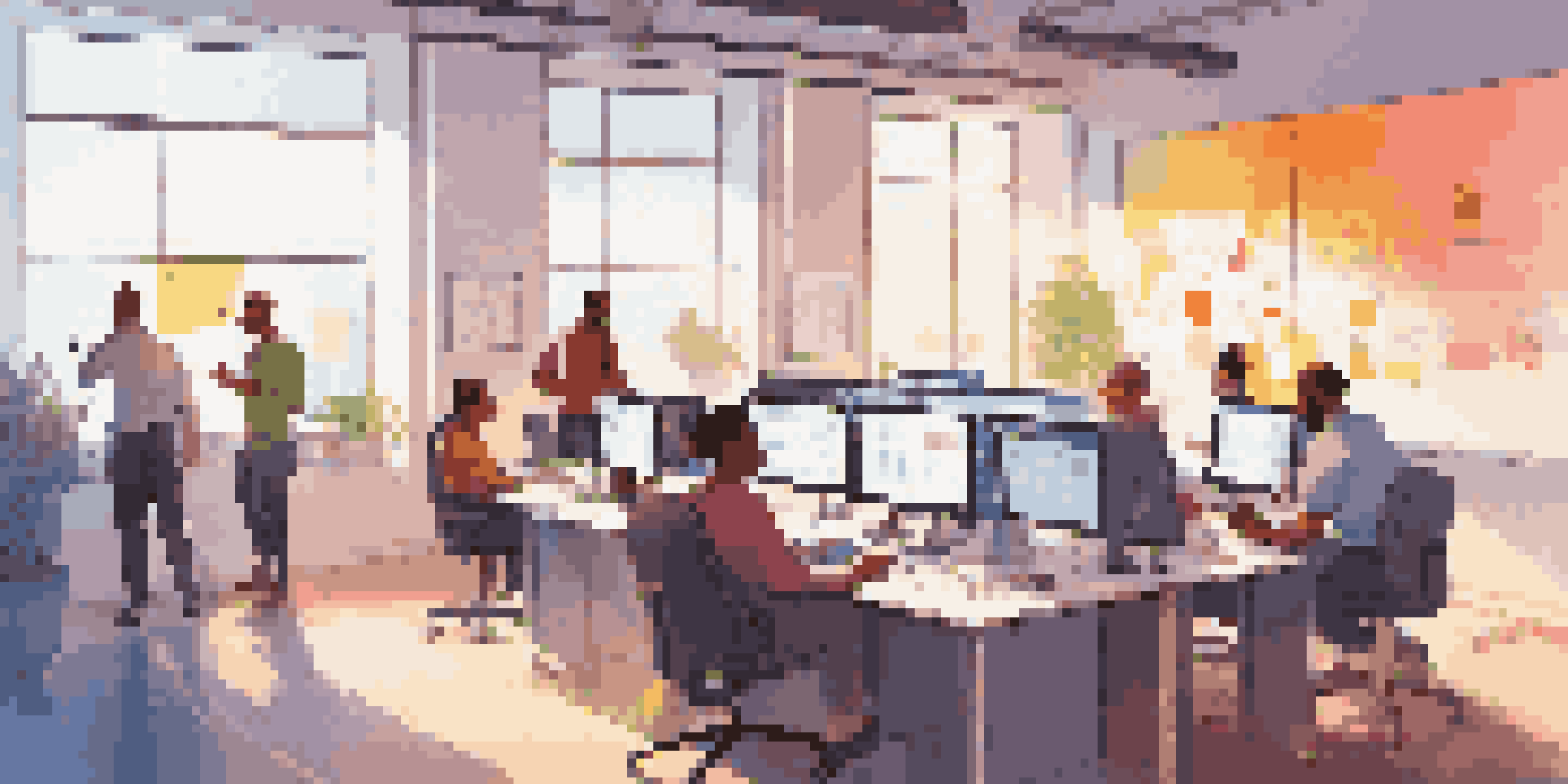 A bright office space where a diverse group of people are collaborating on a low-code development project with screens and whiteboards around them.