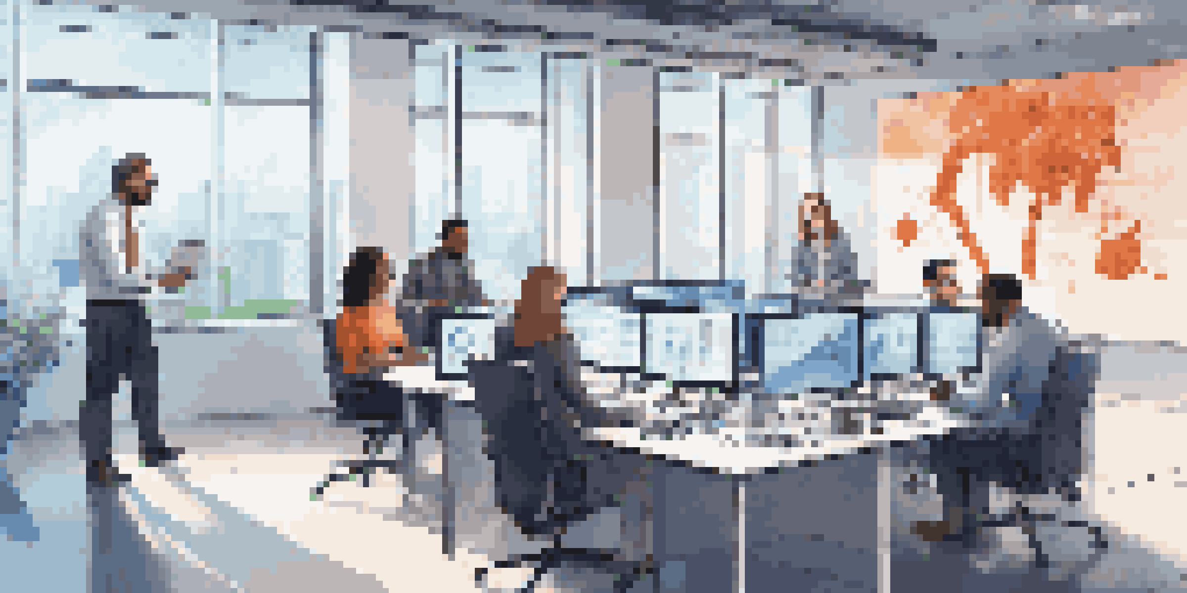 A diverse team of professionals in a modern office discussing cybersecurity strategies with laptops open and digital screens in the background.