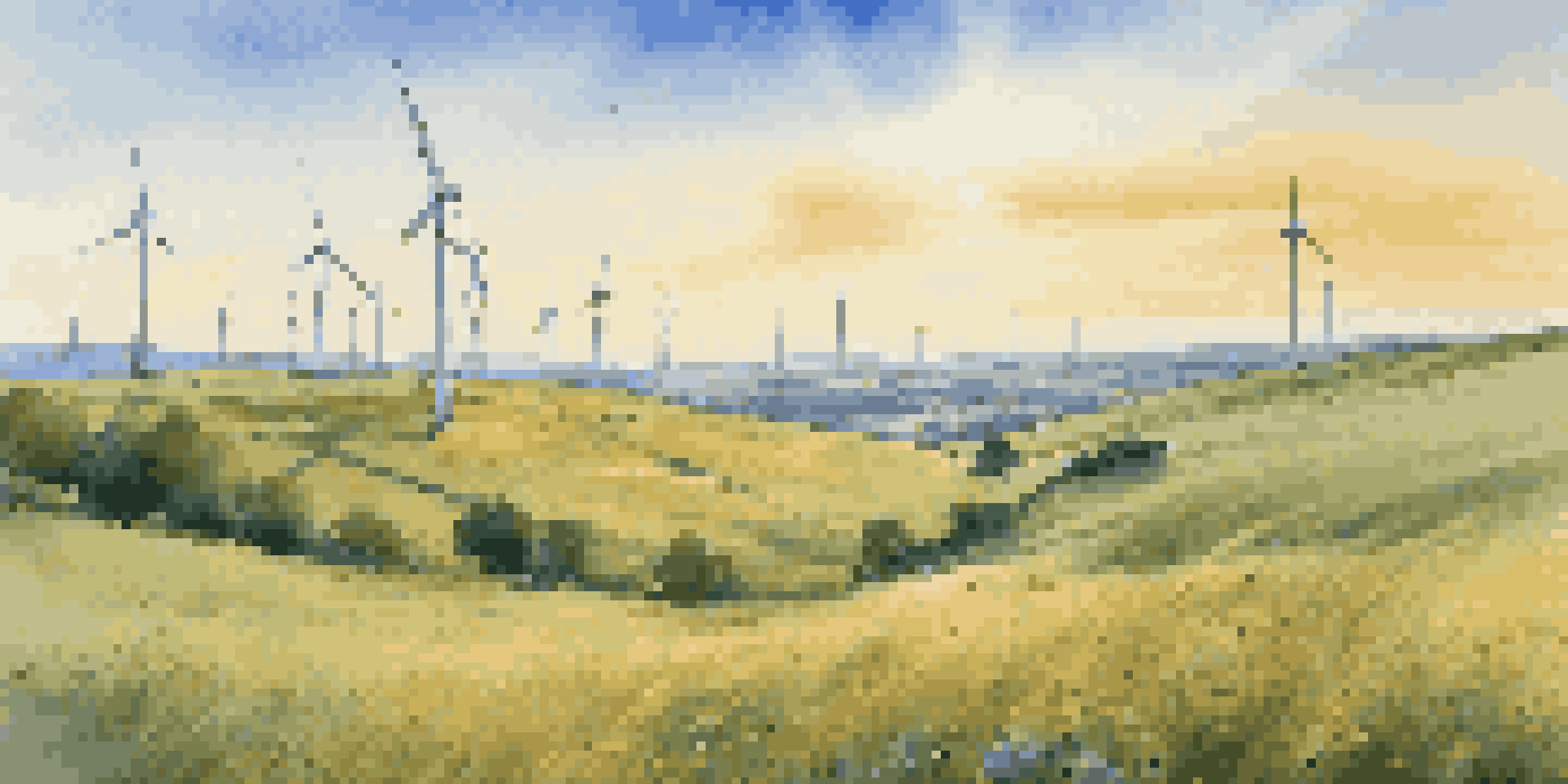 A peaceful view of a wind farm with spinning turbines on green hills under a clear blue sky, illuminated by sunlight.