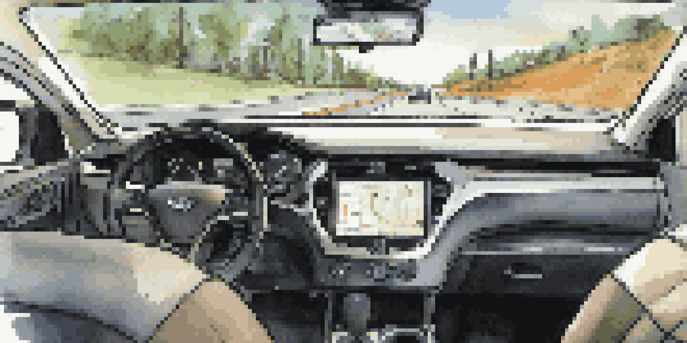 A close-up of a telematics device inside a vehicle, showing real-time data on a screen.