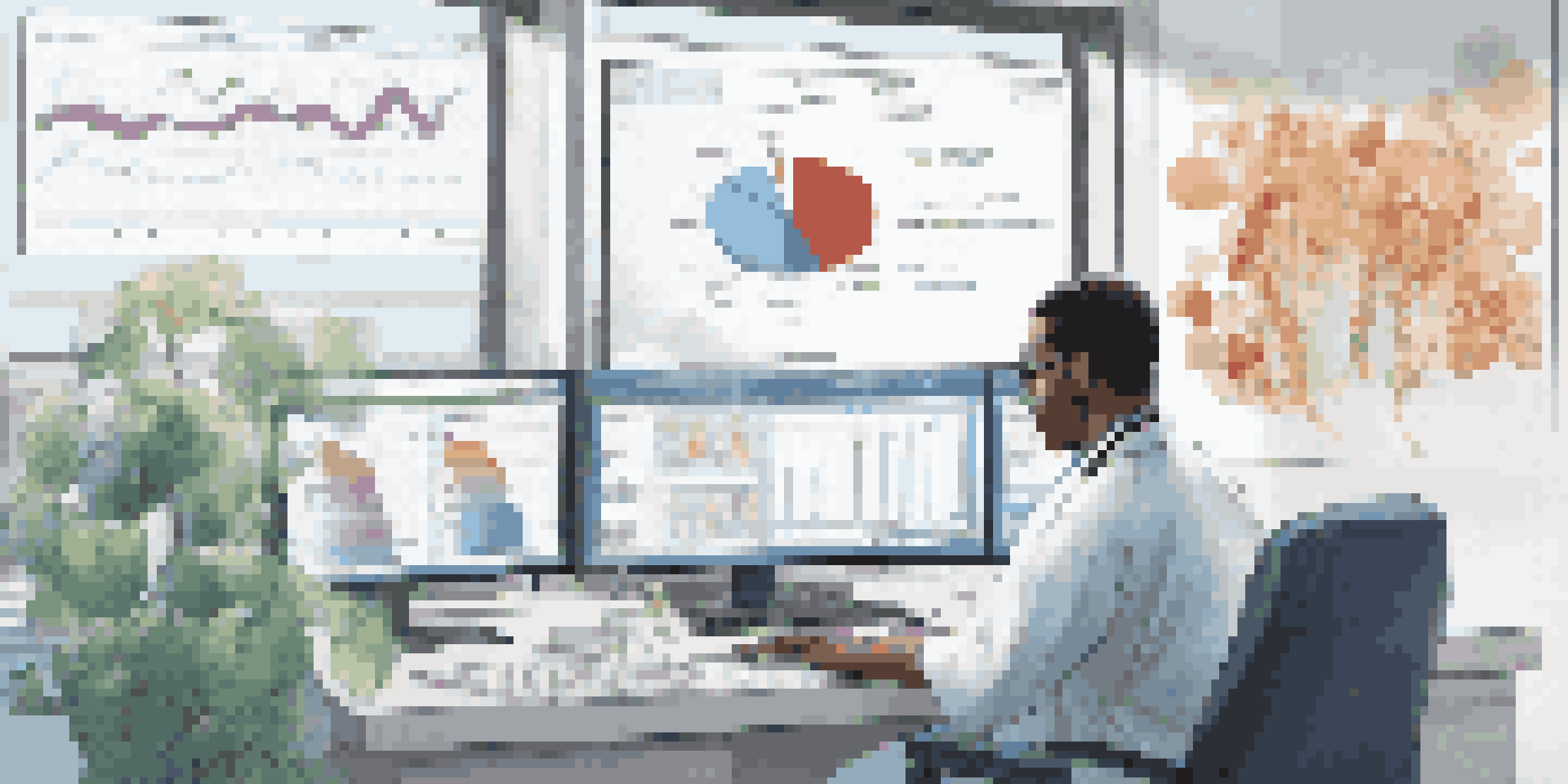 A healthcare professional working on a computer with medical charts and patient files in a bright, modern office.