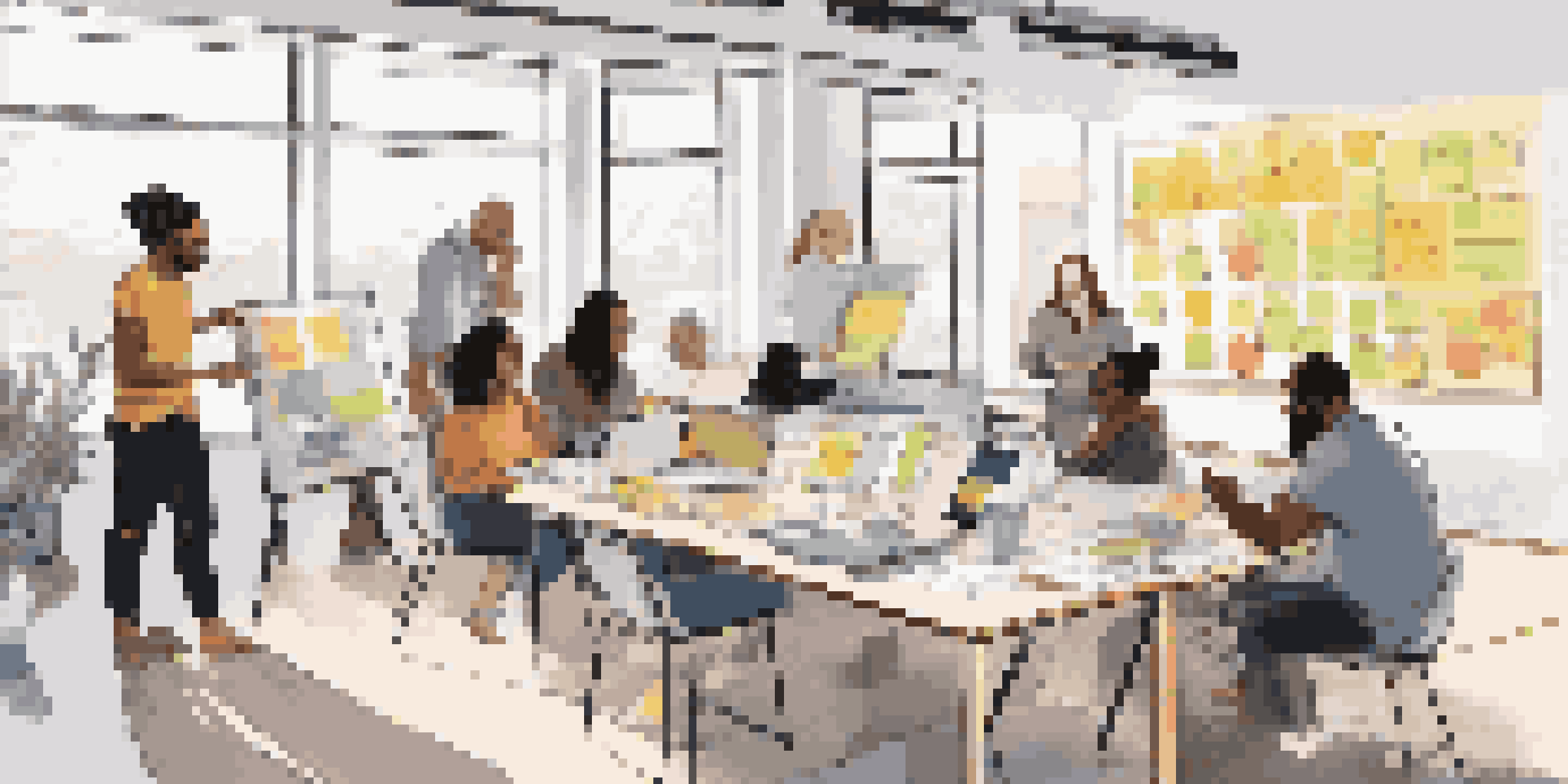 A diverse group of individuals collaborating on design ideas in a bright room filled with sketches and digital devices.