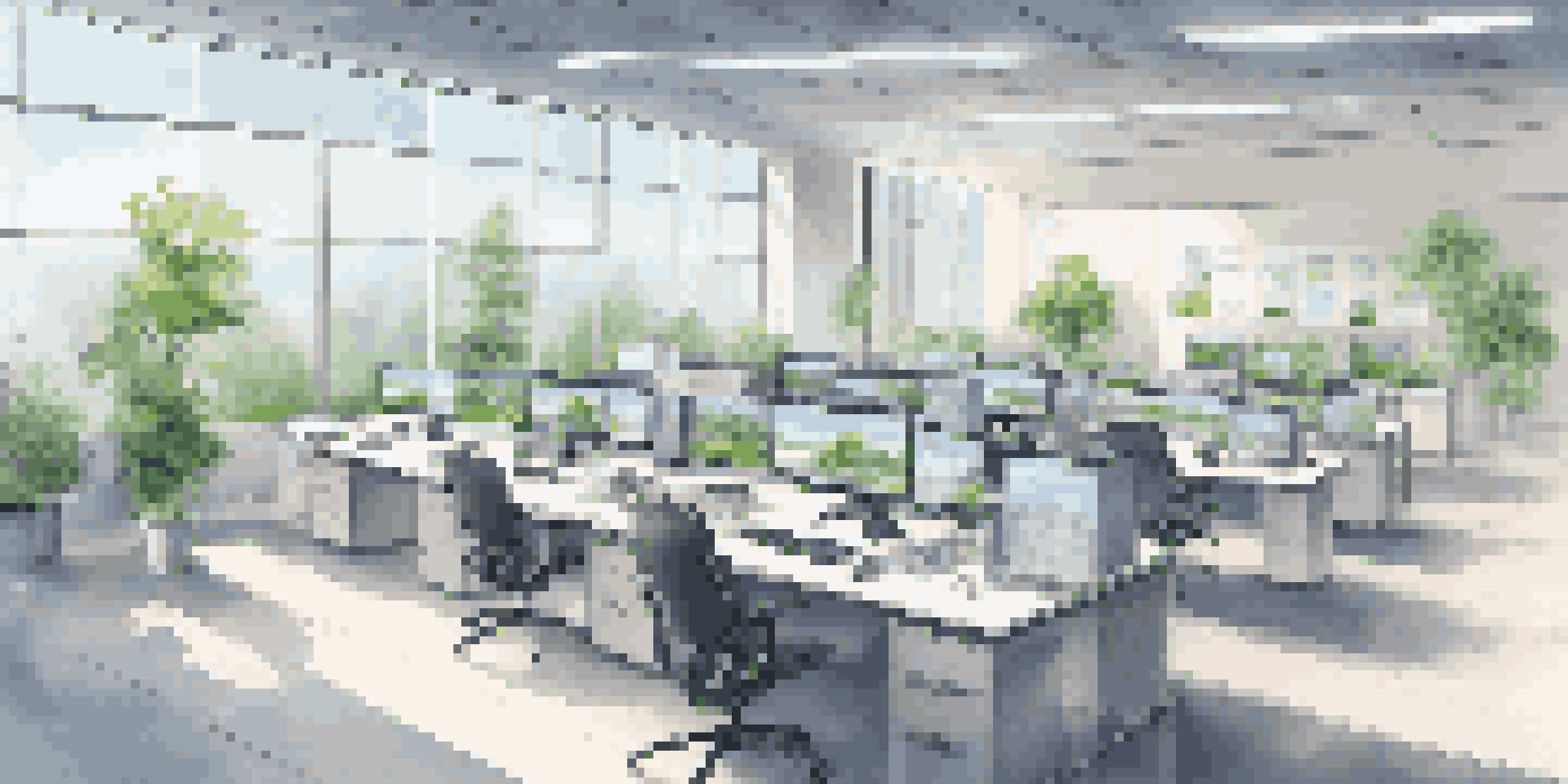 A modern and bright office with virtual desktops on sleek monitors and large windows showing greenery outside.